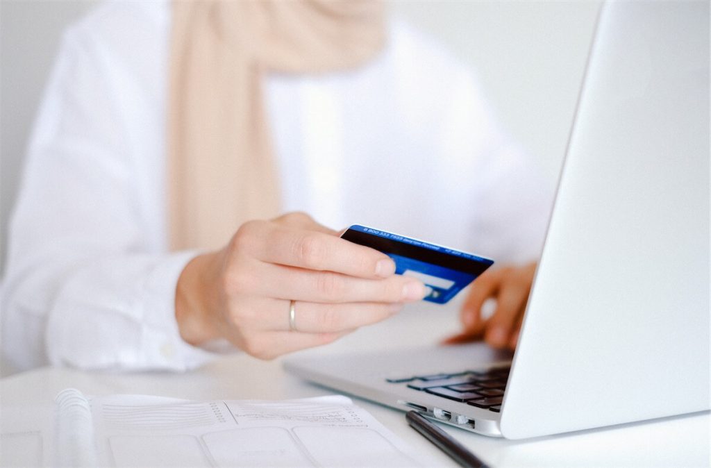 Woman looking at her credit card bill on her laptop, which accounts for part of her TDSR