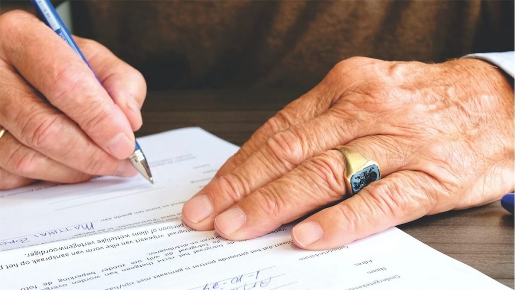 Man signing a loan contract for his home loan
