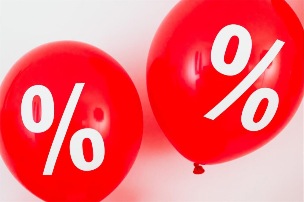 Two red balloons with the percentage sign showing low-interest rates for FinanceGuru’s processed TBLP applications