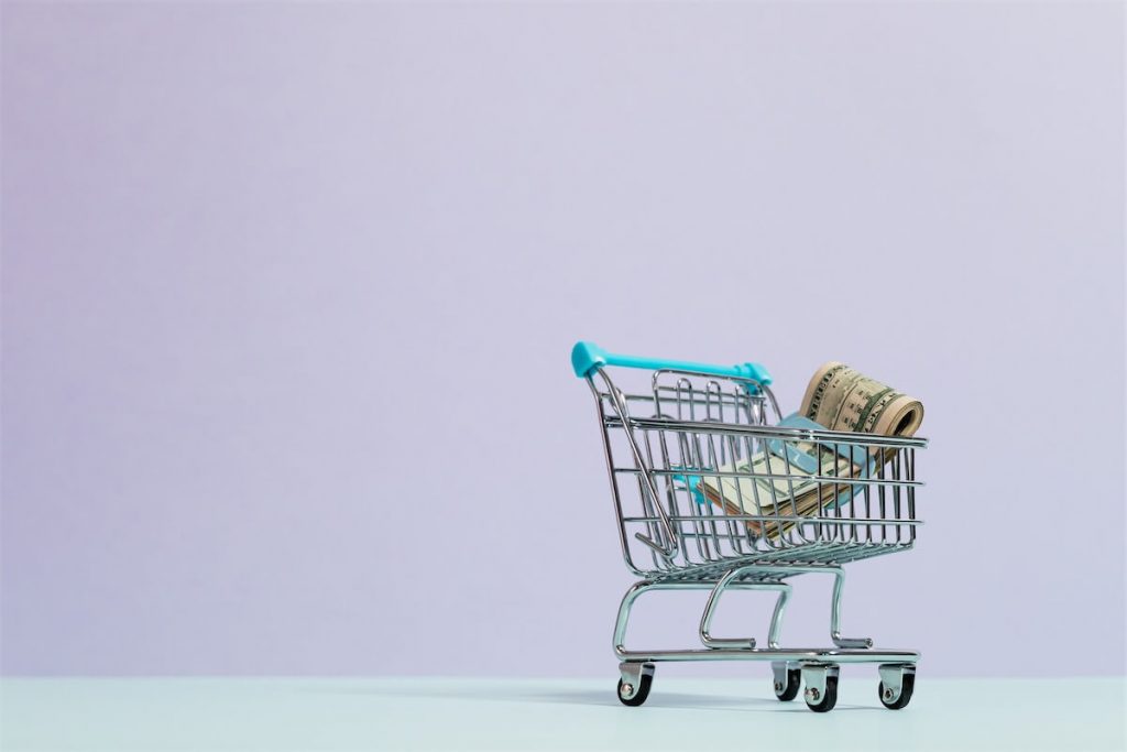 A mini shopping cart with a bundle of cash in it, illustrating how much you can borrow on a personal loan in Singapore