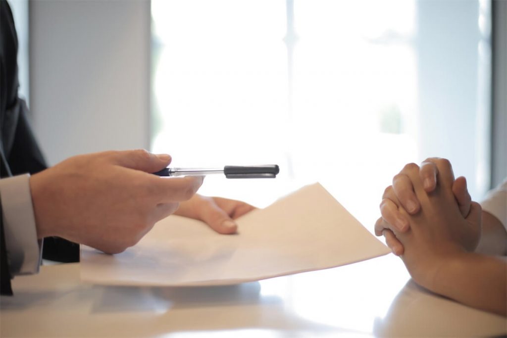 A customer representative handing over a pen to a customer requesting an AIP for her private property purchase