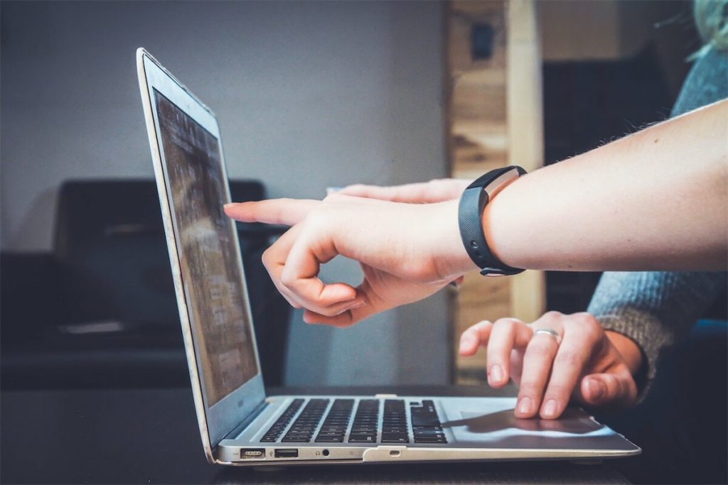 A mortgage broker guiding a customer through his home loan options on a laptop