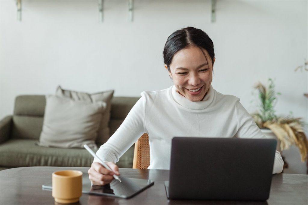 Woman smiling and taking notes of her monthly savings yielded through her refinance plan