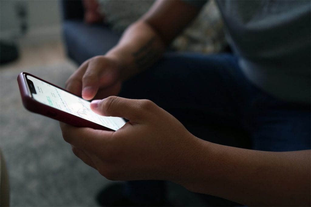 Man checking his investments on an online trading platform and evaluating how this will affect his property investments in Singapore