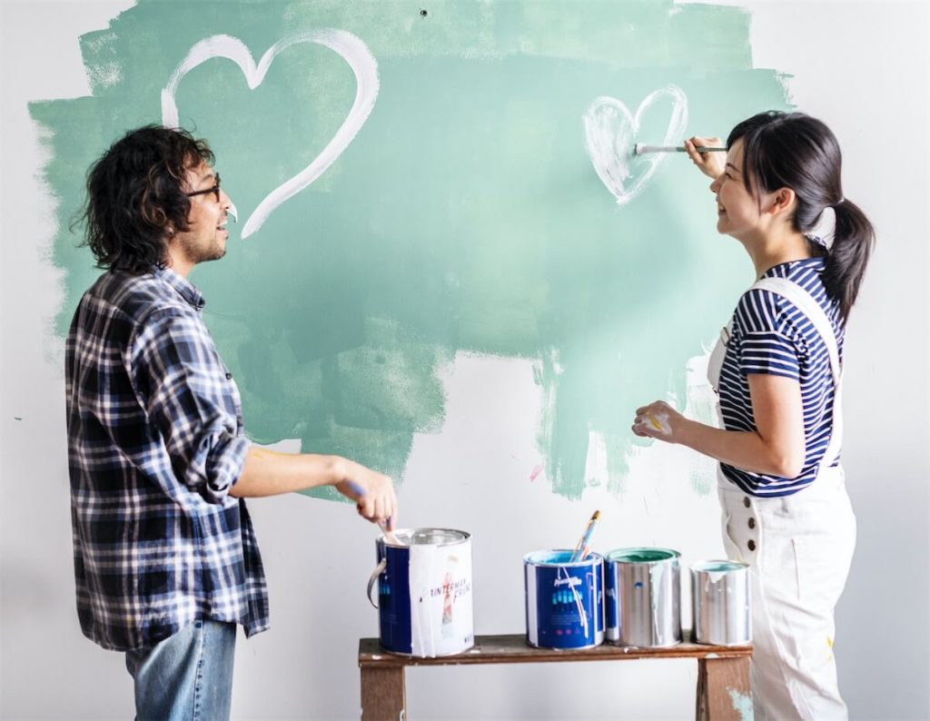 Couple decorating their new home - living in your property makes it an owner-occupied property, and you’re subject to lower property tax in Singapore.