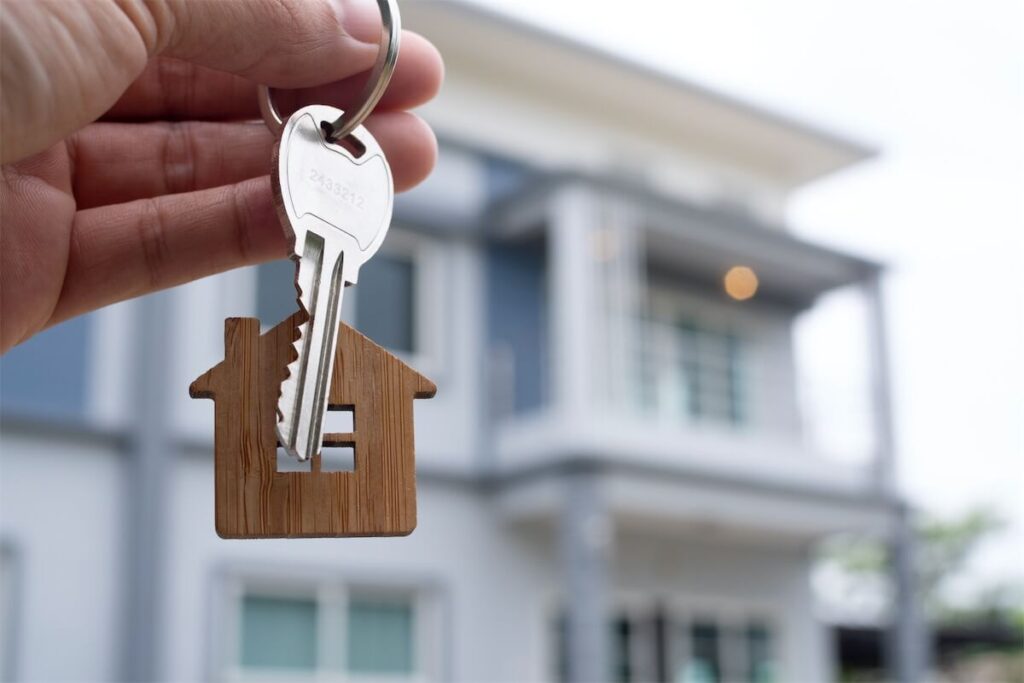 Image of a person holding their house keys in front of their landed property in Singapore
