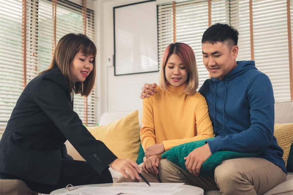 Young couple and a mortgage broker in Singapore looking at the options for home loans for their new HDB BTO