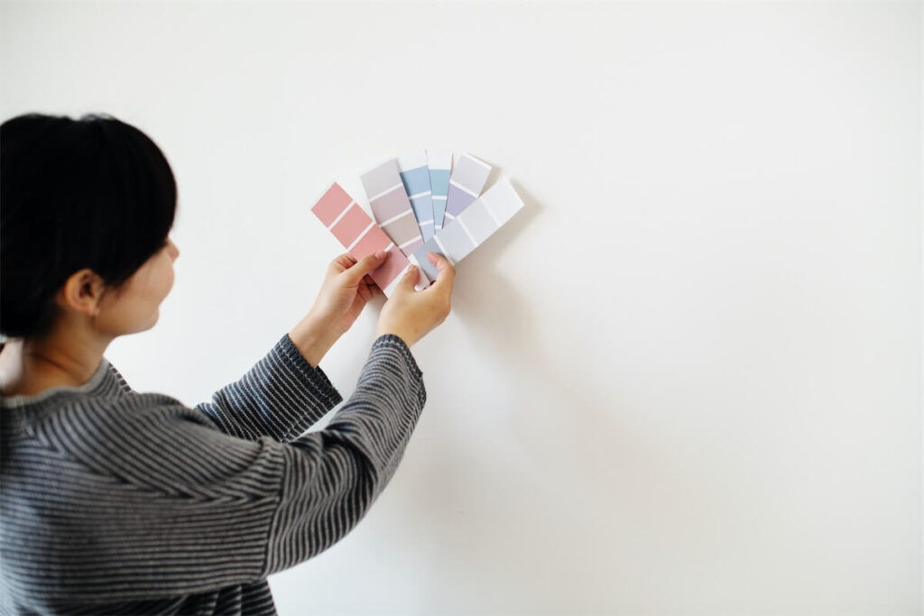 Woman looking at colour swatches to paint the walls in her new EC in Singapore