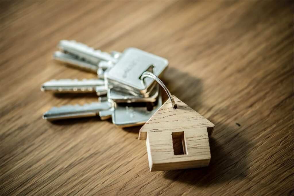  Images of a house key on a table with a miniature house accessory
