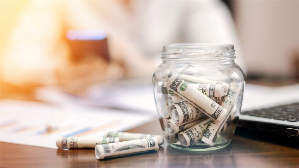  Image of a jar filled with cash notes to symbolise considering your financial situation when making a home loan refinance decision