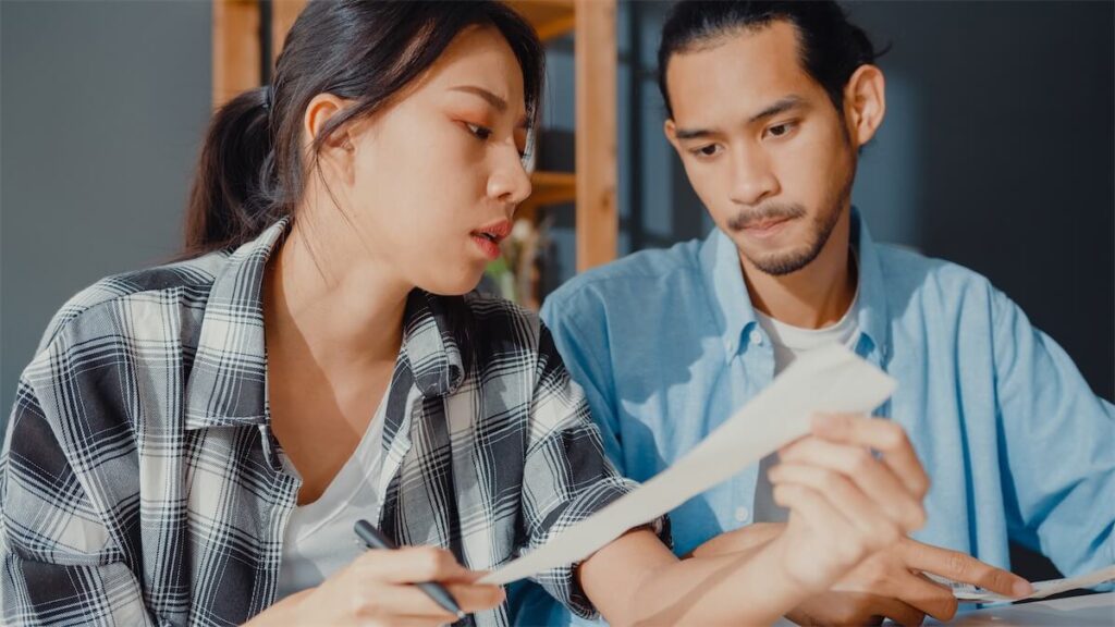 A couple looking at their HDB loan eligibility paperwork during their HDB BTO application process in Singapore